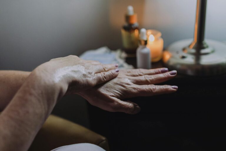 Hand care with lotion in a soothing spa ambiance, featuring candles and relaxation elements.