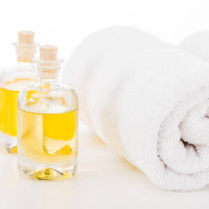 Studio shot of towels and bottles of manicure oil isolated on white