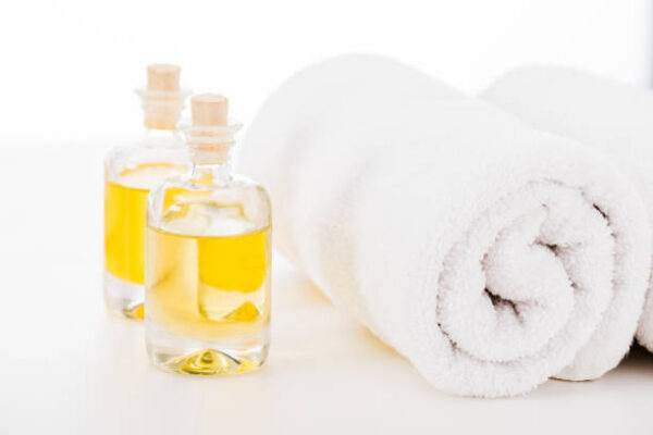 Studio shot of towels and bottles of manicure oil isolated on white