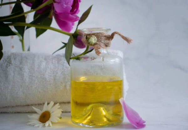 Oil cosmetic flower chamomile on a light background